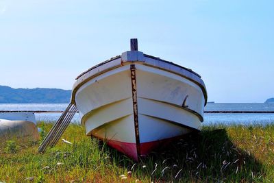 Boat moored on beach against clear sky