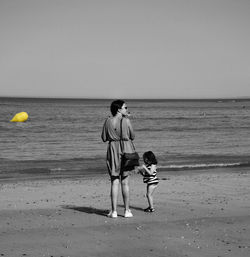 Boy enjoying on beach against sky