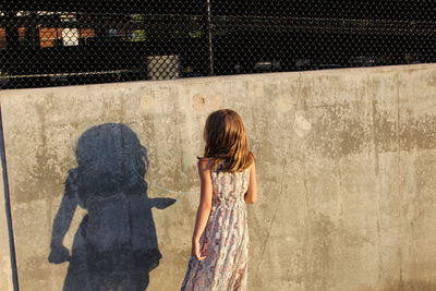 Rear view of woman standing on road
