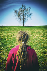 Rear view of woman on field against sky