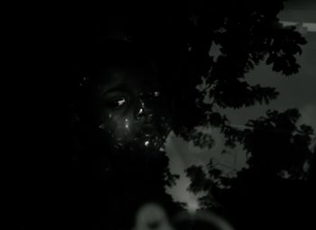 Close-up portrait of young woman against trees