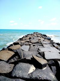 Close-up of rock by sea against sky