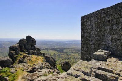 View of rocks on landscape against sky