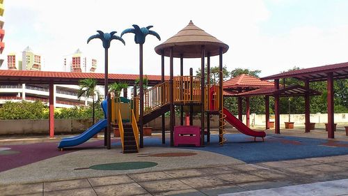 Playground in city against sky