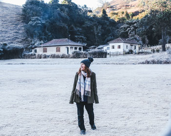 Rear view of woman standing on snow covered landscape