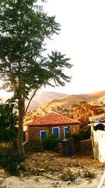 House amidst trees and buildings against clear sky