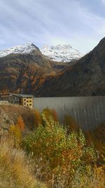 Scenic view of dam and mountains against sky