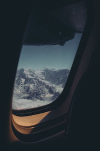 Scenic view of snowcapped mountains seen through window