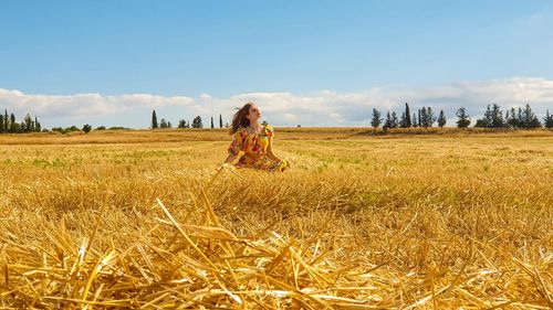 Woman standing on field against sky