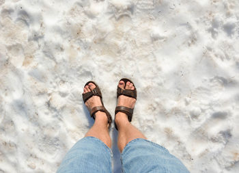 Low section of man standing on sand