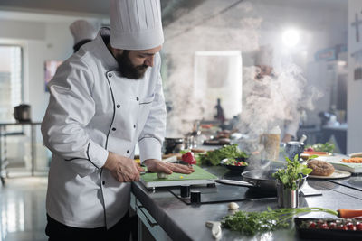 Side view of man preparing food in kitchen