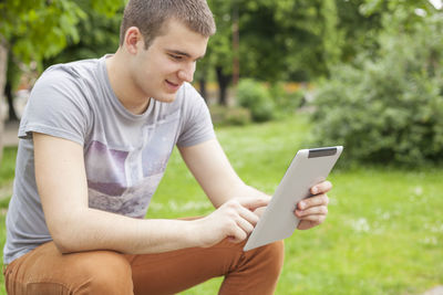 Boy looking away while sitting on mobile phone