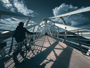 Low angle view of man on bridge against sky