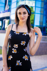 Portrait of young woman standing against wall