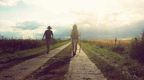 Rear view of person standing on dirt road