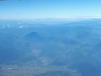 Aerial view of mountains against blue sky