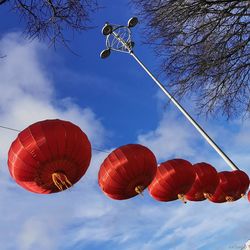 Low angle view of lanterns hanging against sky