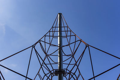 Low angle view of metallic bridge against clear blue sky