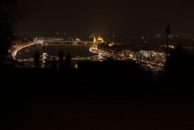 Illuminated cityscape against sky at night