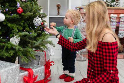 Side view of woman holding christmas tree