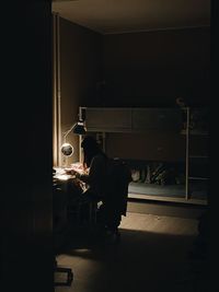 Rear view of man sitting in room