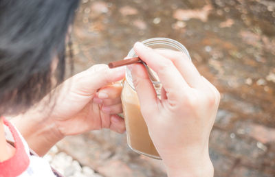 High angle view of hand holding beverage and straw