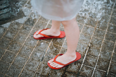 Low section of woman standing on footpath