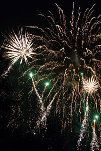 Low angle view of firework display against sky at night