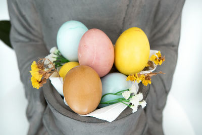 Close-up of person holding eggs on white surface