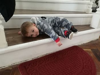 Cute boy lying on floor at home