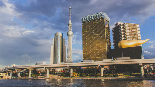Low angle view of tokyo sky tree by sumida river against sky