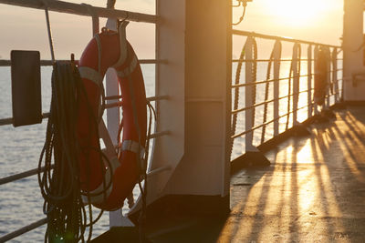 A lifesaver ring in sunset light on deck of a ferry ship.