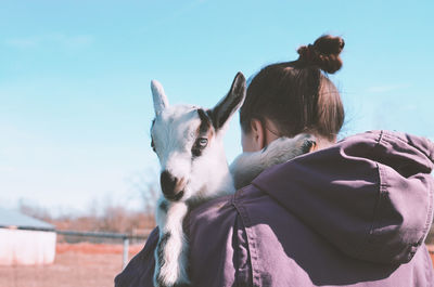 Woman with goat against sky