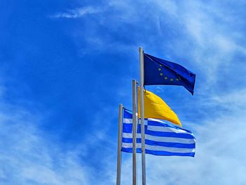 Low angle view of flag against blue sky