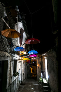 Low angle view of illuminated lanterns hanging by building at night