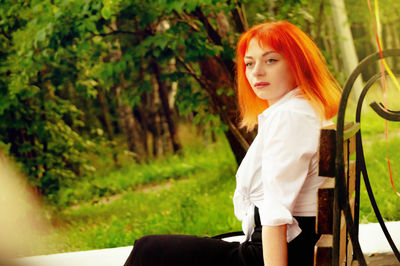 Portrait of beautiful woman against trees