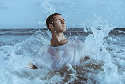 Full length of shirtless man in sea