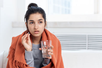 Portrait of young woman drinking drink