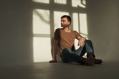 Handsome young man in t-shirt and jeans alone