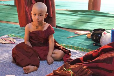 Portrait of monk sitting on blanket