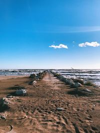 Scenic view of beach against blue sky