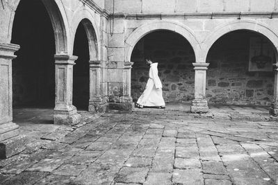 Full length of female statue against brick wall