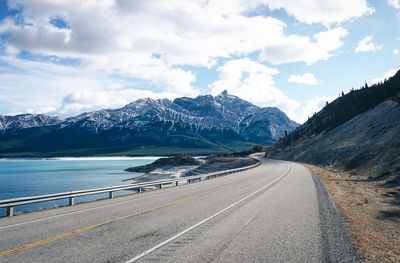 Road by mountains against sky