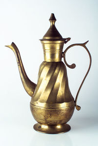 Close-up of electric lamp on table against white background