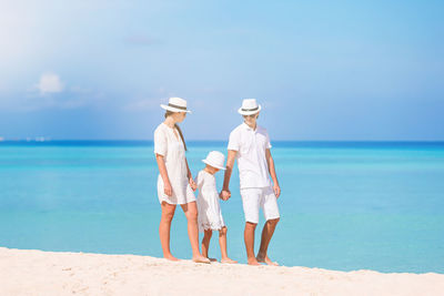 Women standing on beach against sky