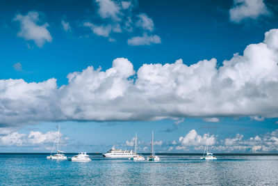 Sailboats in sea against sky