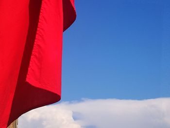 Low angle view of flag against blue sky