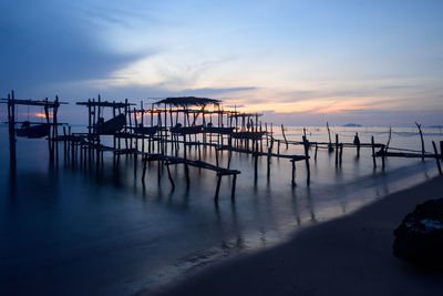 Silhouette pier on beach against sky during sunset