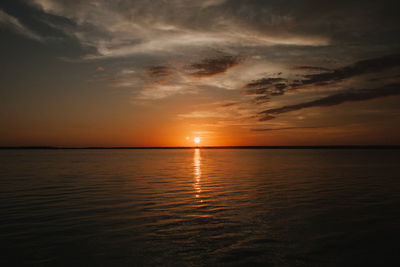 Scenic view of sea against dramatic sky during sunset