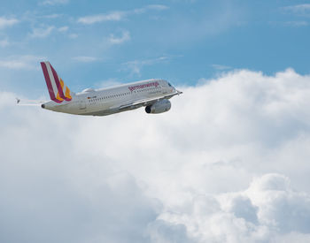 Low angle view of airplane flying against sky